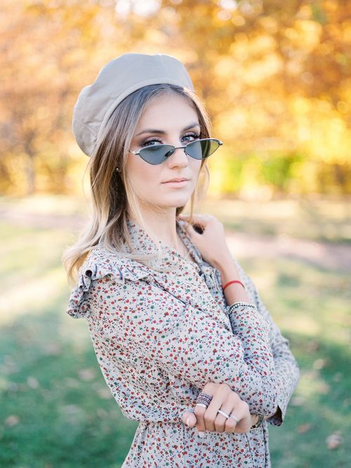Free Stylish young woman wearing beret and sunglasses in vibrant autumn park. Stock Photo