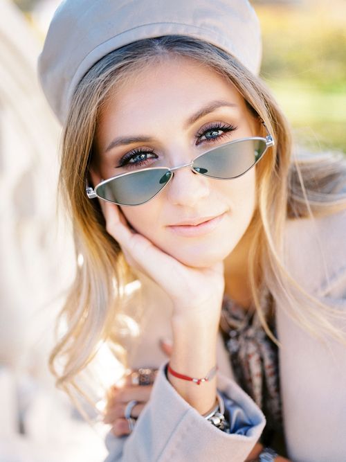 Free Portrait of a stylish woman with sunglasses and beret, smiling outdoors on a sunny day. Stock Photo