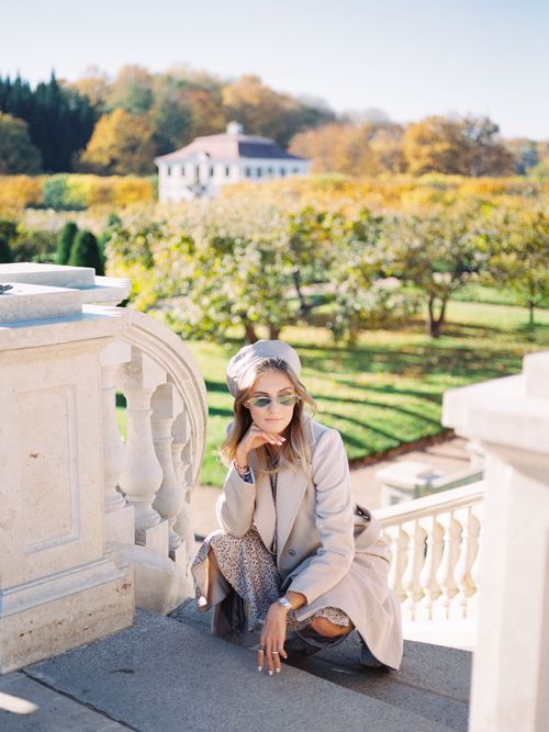 Free Stylish woman crouching by a balustrade in an elegant park during autumn. Stock Photo