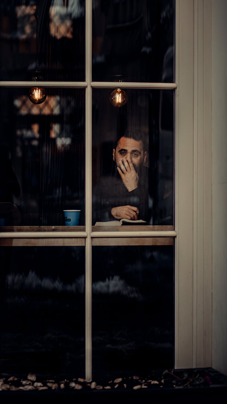 Photo Of A Man Sitting At The Table 