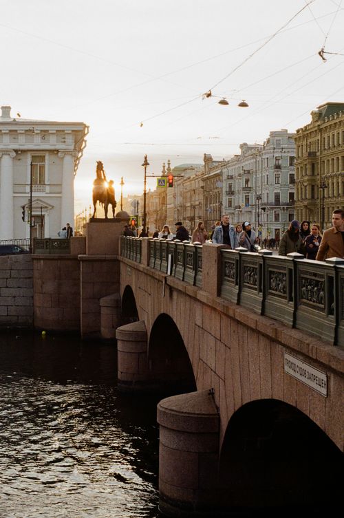 Free Scenic view of a stone bridge over a canal with people at sunset in Saint Petersburg, Russia. Stock Photo