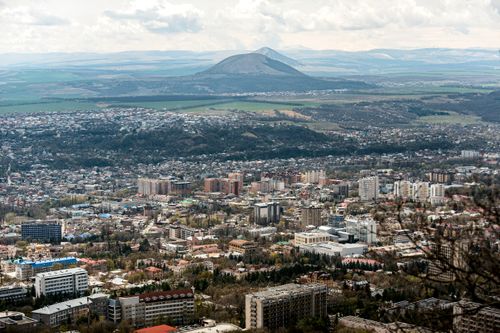Free Aerial view of Pyatigorsk city with mountains and buildings under cloudy skies. Stock Photo