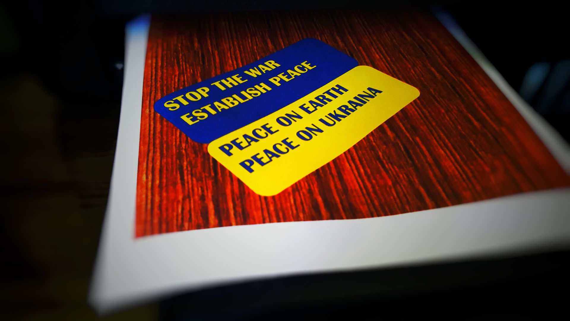 Close-up of peace message placard with yellow and blue colors promoting stop war and peace in Ukraine.