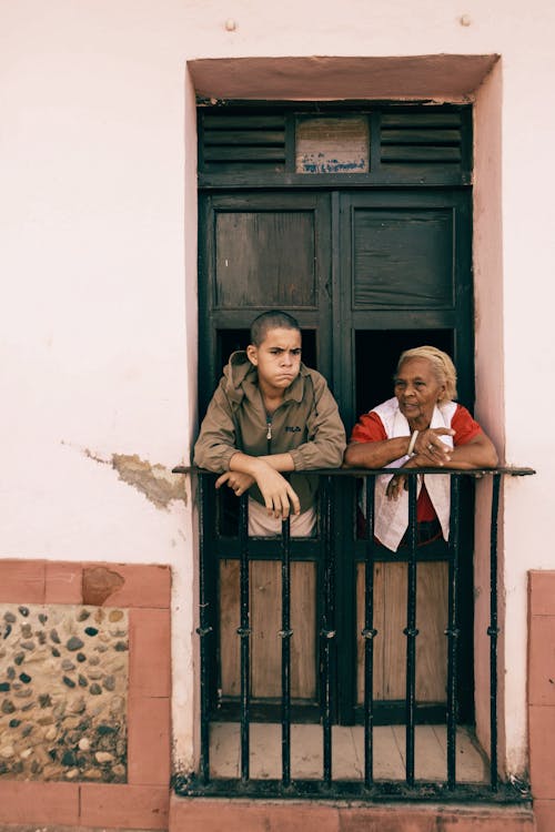 Free Elderly Woman and a Boy Talking on a Balcony Stock Photo