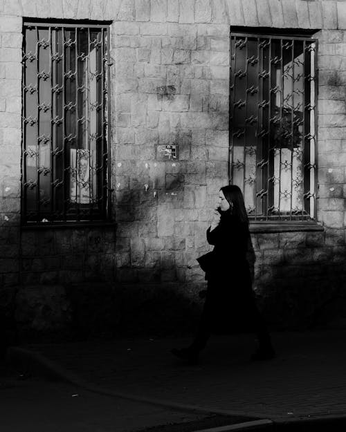 Free Grayscale Photo of a Woman Walking on the Street Stock Photo