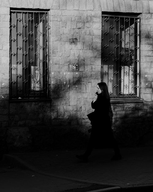 Free Black and white silhouette of a woman walking by a historic building in Saint Petersburg. Stock Photo