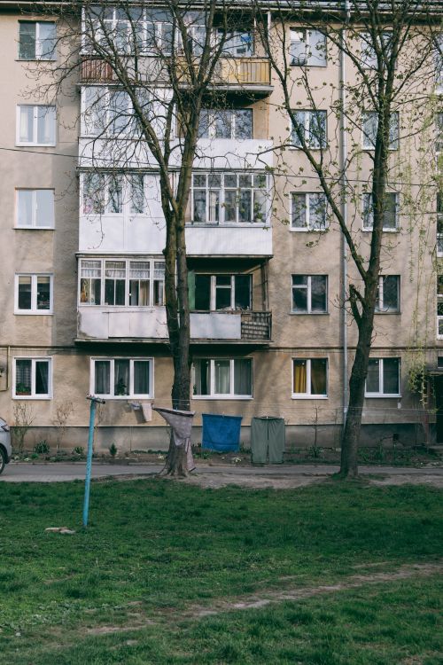 Free Urban residential apartment facade with surrounding greenery and trees. Stock Photo
