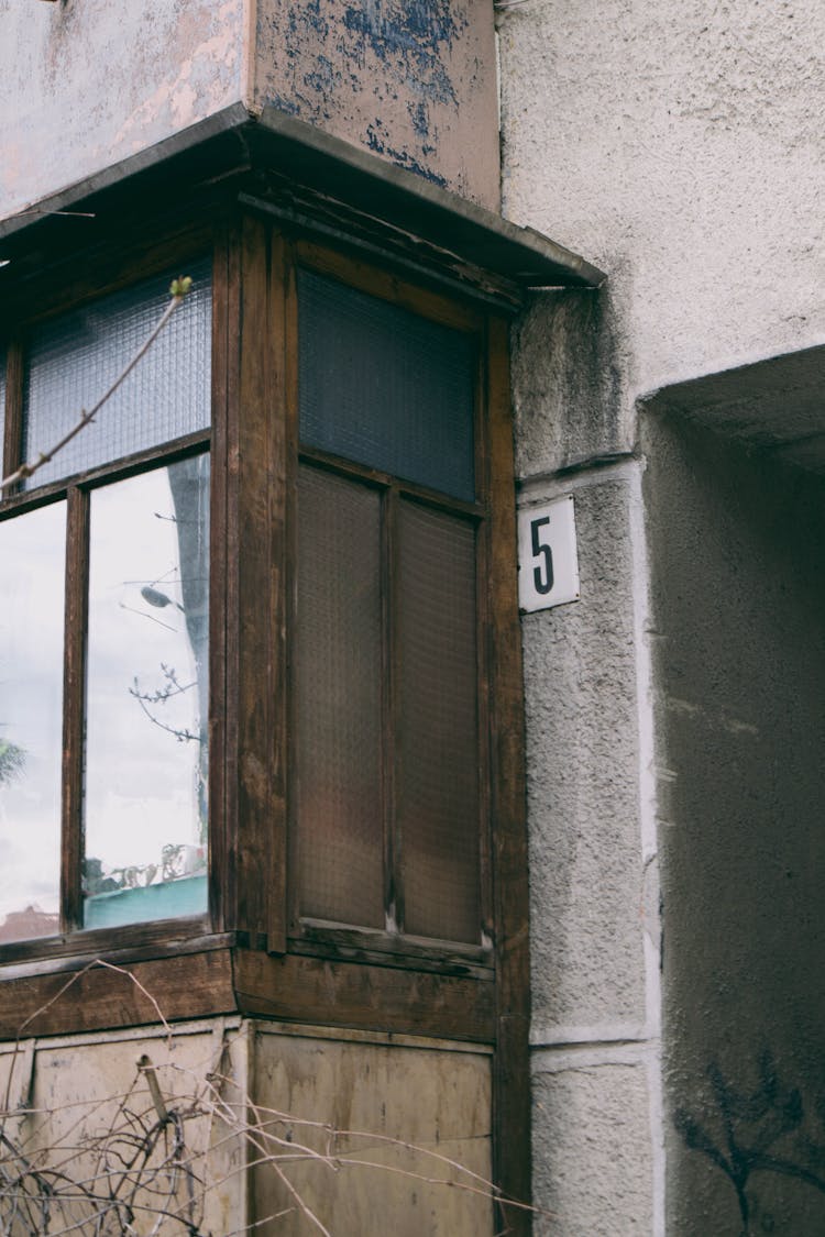 A Number Posted Outside A Concrete Wall Of A Family House