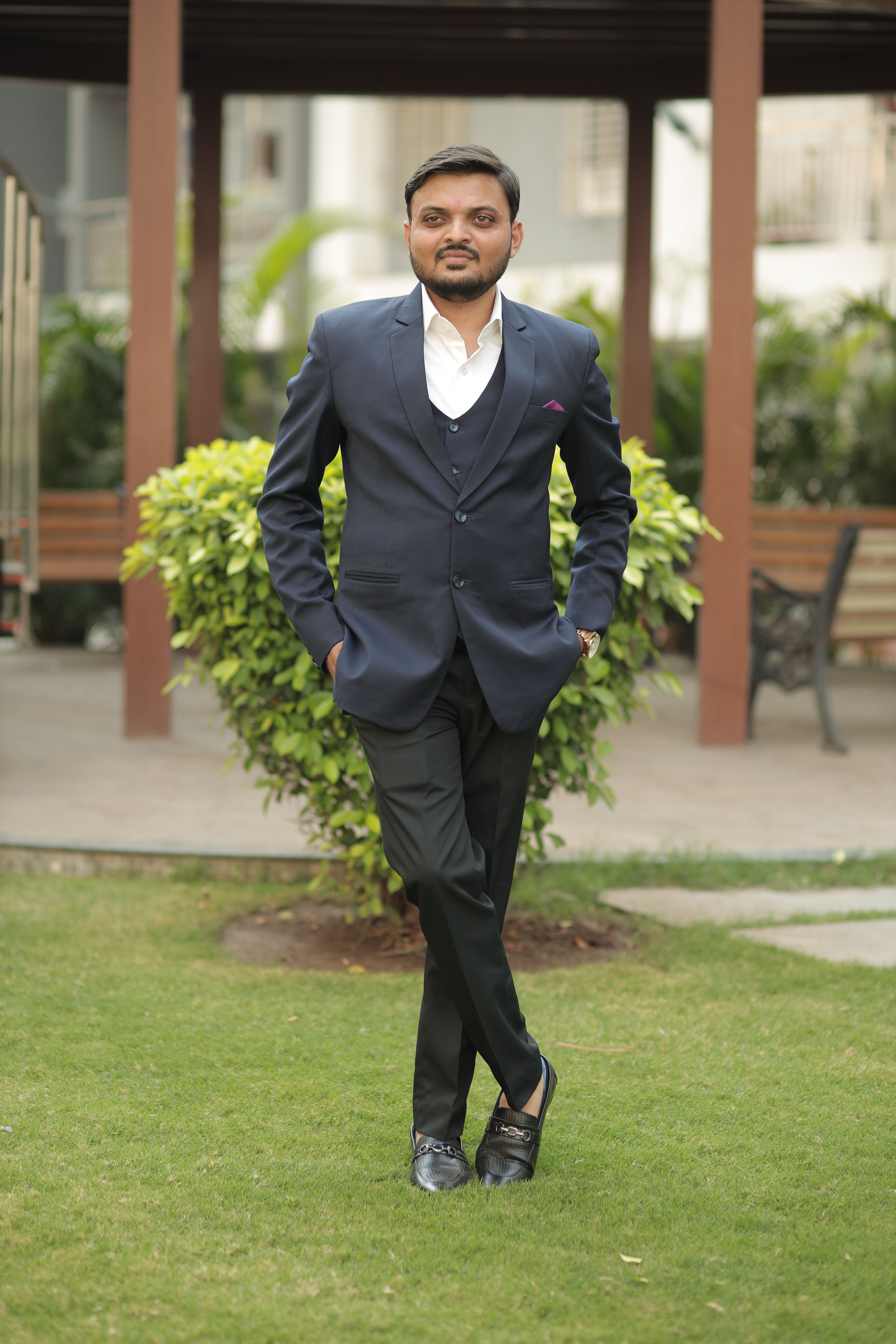A man standing confidently in a suit outdoors, exuding elegance and professionalism.