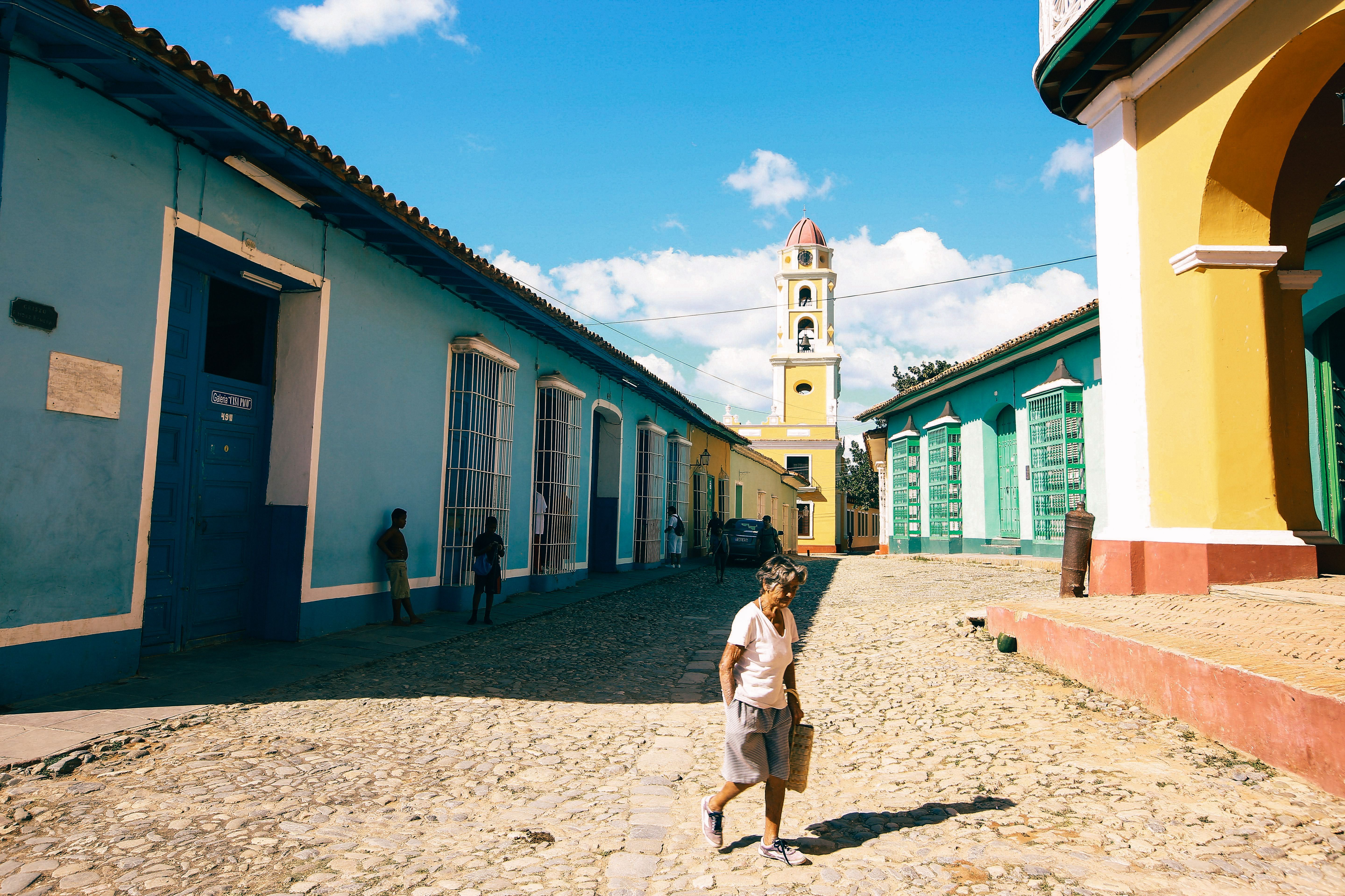 Person wearing lightweight linen clothing walking down a colorful street in Havana, Cuba