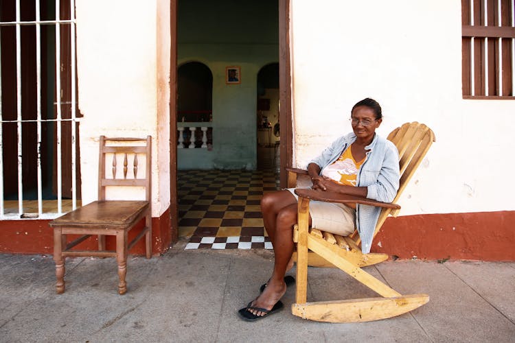 A Woman Sitting On A Wooden Chair