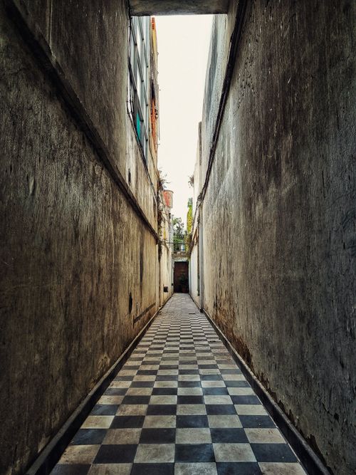 Free Explore the charm of a narrow alleyway in Buenos Aires, featuring classic checkerboard flooring. Stock Photo