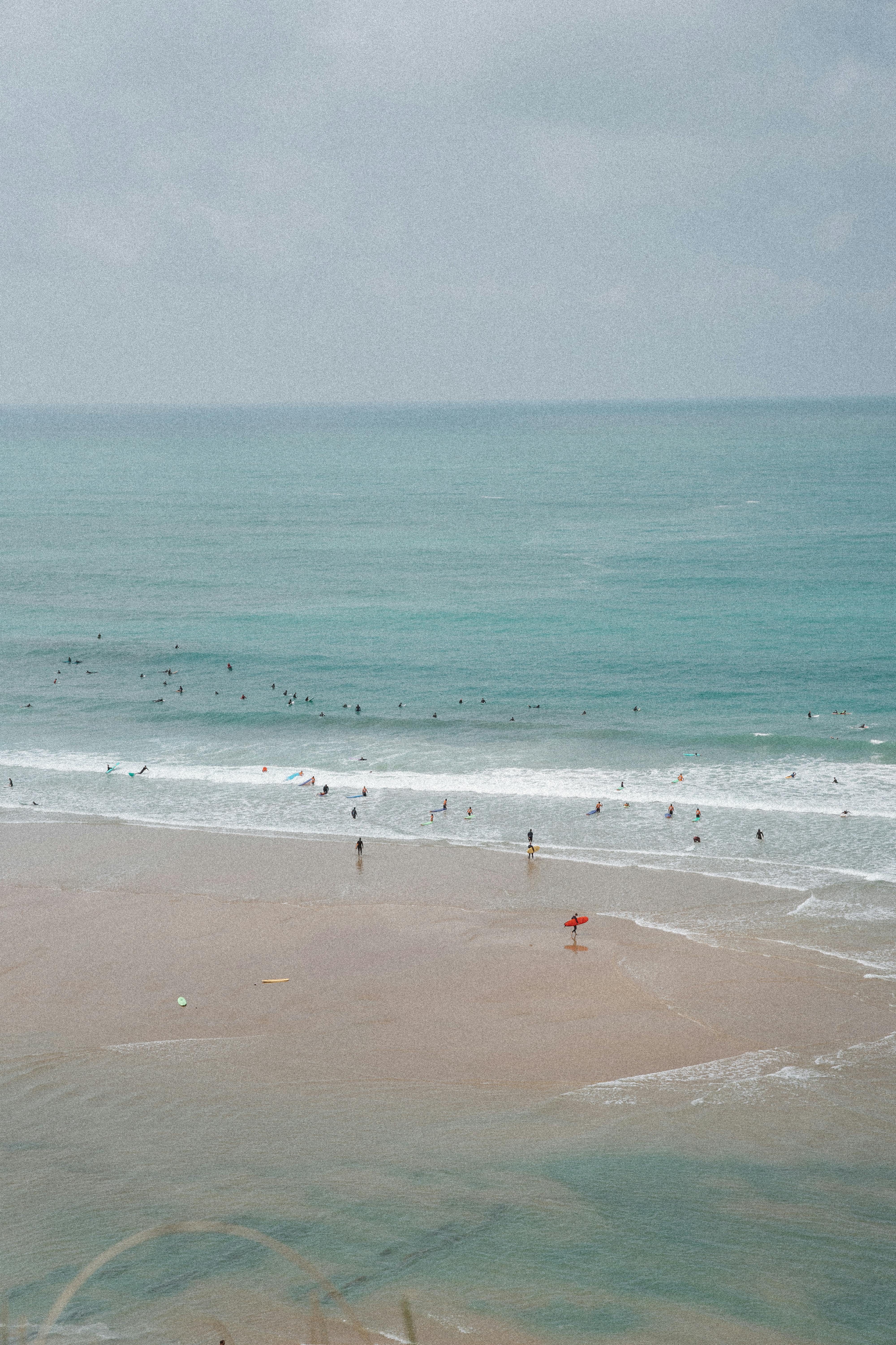 Scenic view of people enjoying the beach at Biarritz, France with gentle waves and clear skies.
