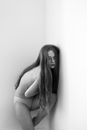 Partly Dressed Curled up Girl with Long Hair Standing in Corner