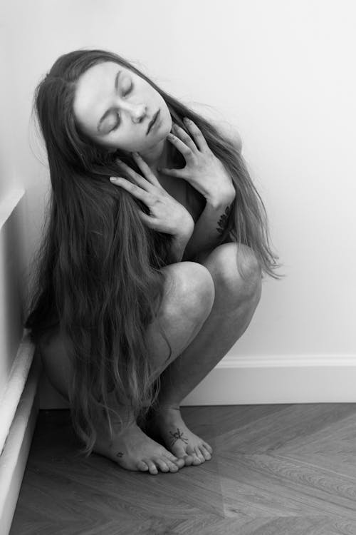 Black and White Photo of a Woman Crouching