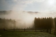 Morning Fog over Meadows and Pastures in Mountains