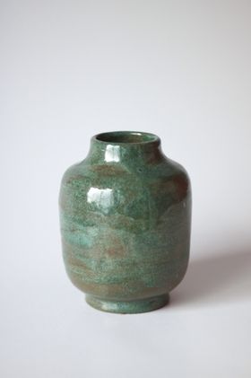Green ceramic vase against a plain wall &mdash; photo by Andreea Ch on Pexels