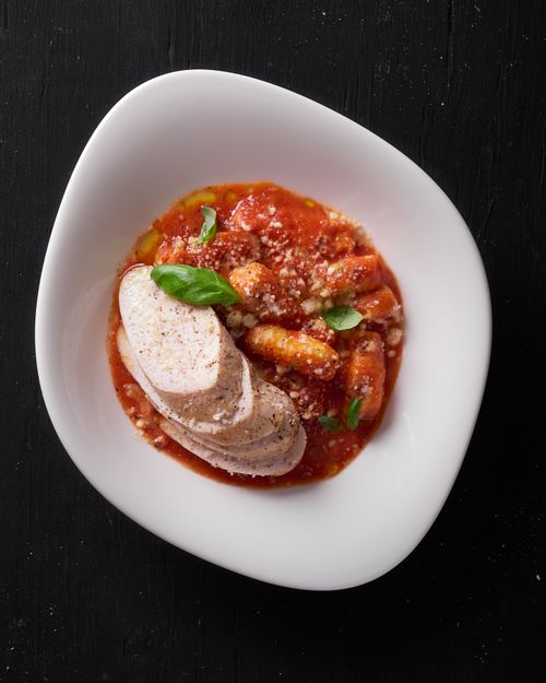 Free Close-up of Italian gnocchi with marinara sauce, cheese, and basil leaves. Stock Photo
