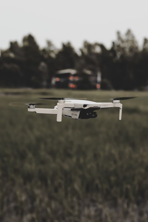 Free A drone captured mid-air in a serene field setting, showcasing modern technology in nature. Stock Photo