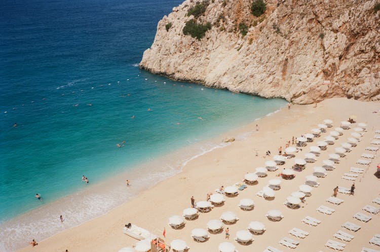 Drone Shot Of People And White Umbrellas At The Beach