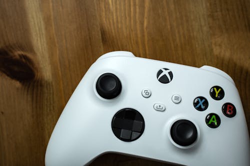 Free Close-Up Shot of a White Game Controller on a Wooden Surface Stock Photo
