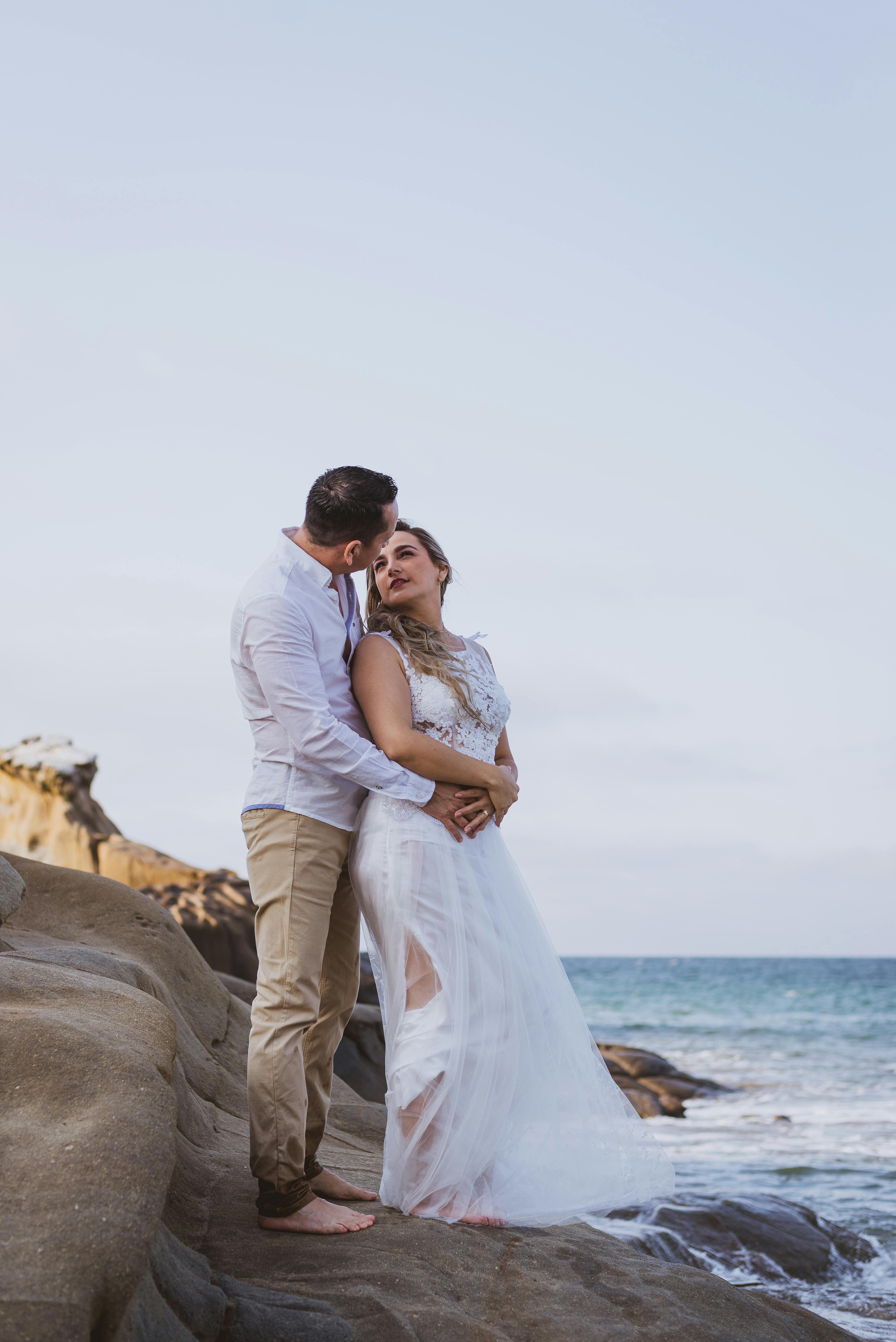 Photo of a Man Lifting Woman Near Body of Water · Free Stock Photo