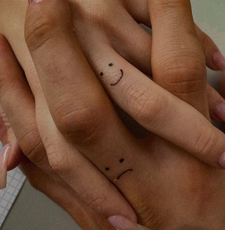 Photo Of A Intertwining Fingers With Painted Emoticons