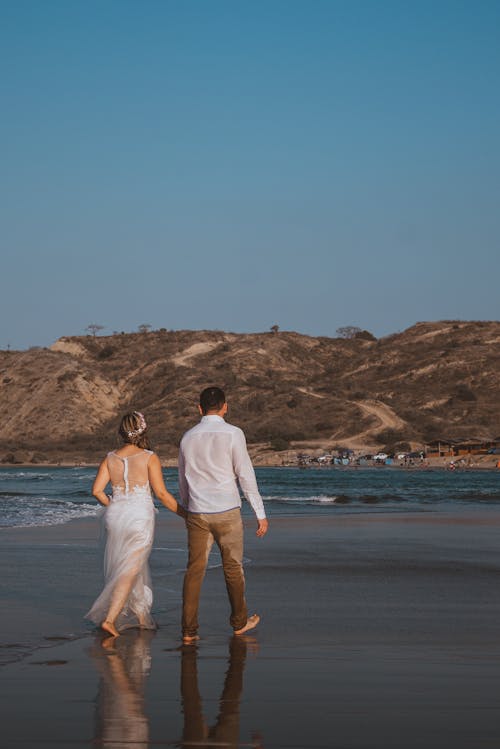 Free A Romantic Couple Walking on the Beach Stock Photo