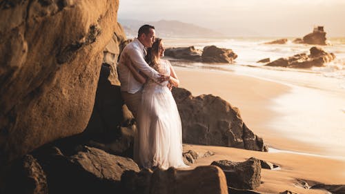 Free A Romantic Couple Embracing on the Beach Stock Photo