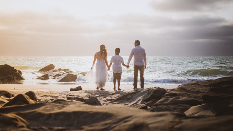 A Family Holding Hands At The Beach