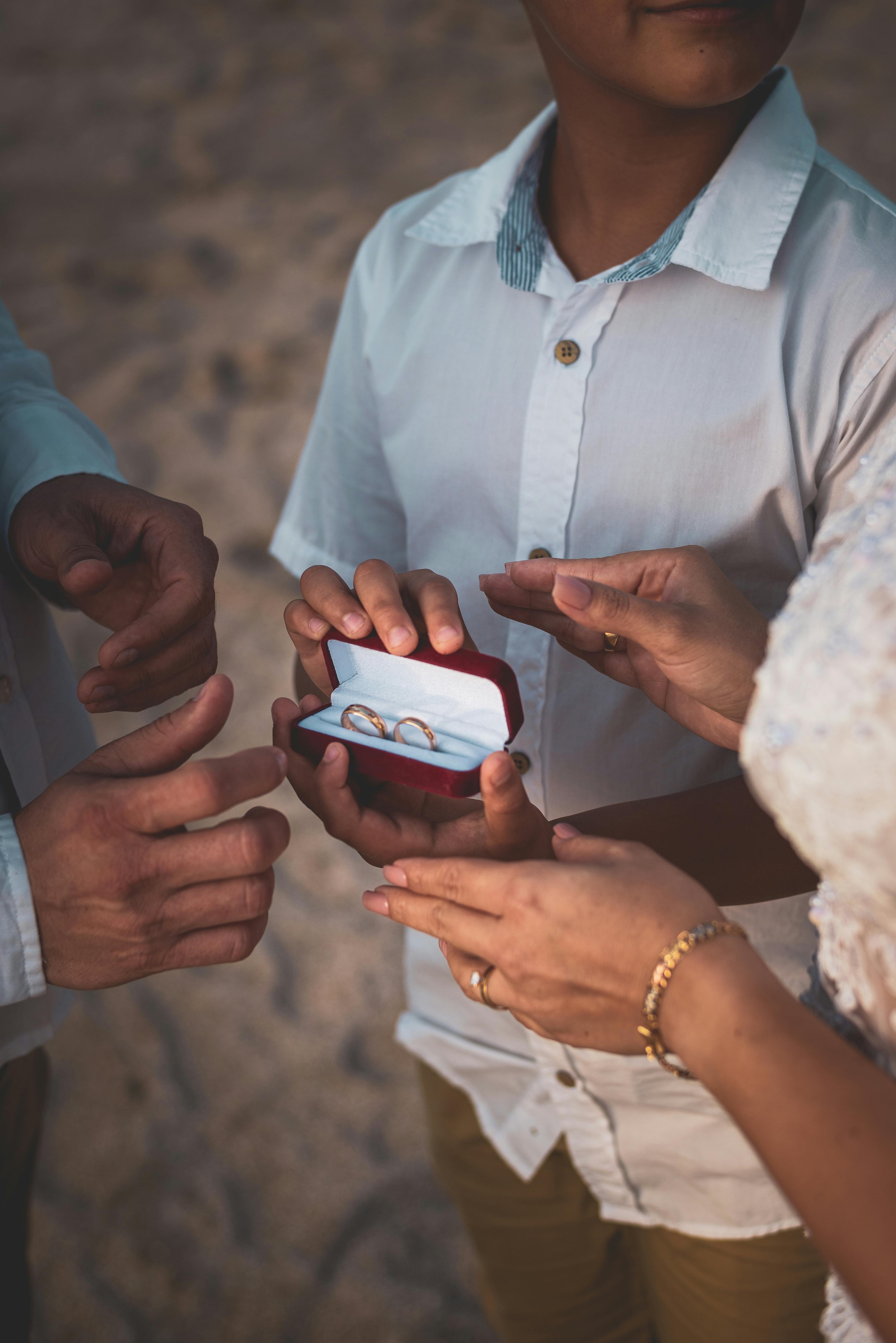 closeup of people trying on wedding rings on a desert