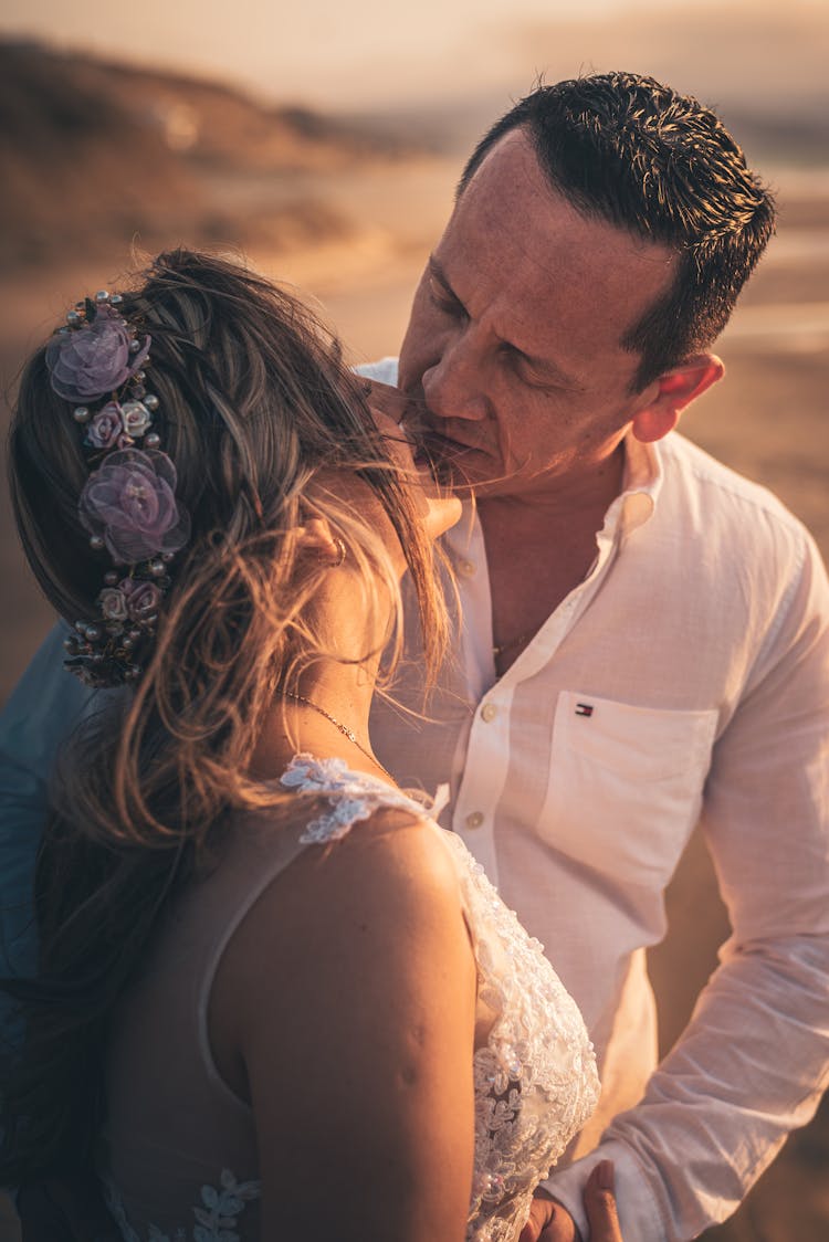 Man In A White Long Sleeve Shirt Kissing A Woman