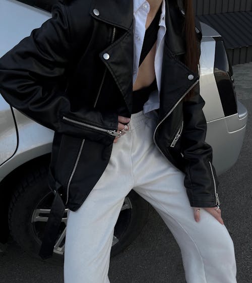 A Person in Black Leather Jacket and White Pants