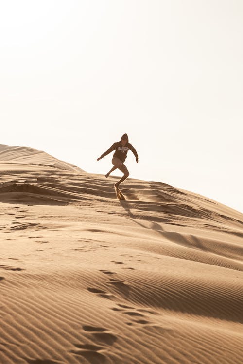 Free A Person Standing on the Sand Dune Stock Photo