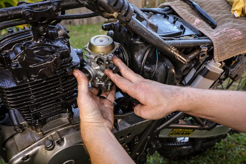 Free Close-Up Shot of a person Fixing an Engine of a Motorcycle Stock Photo