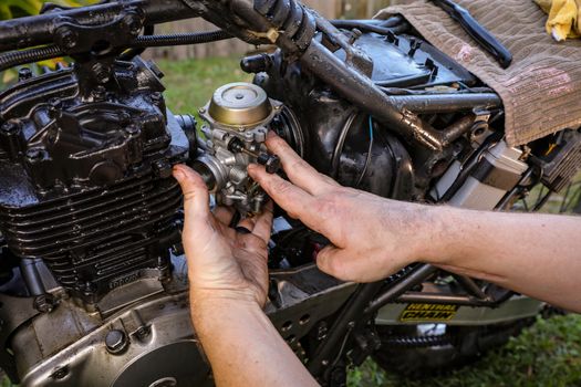 Close-Up Shot of a person Fixing an Engine of a Motorcycle