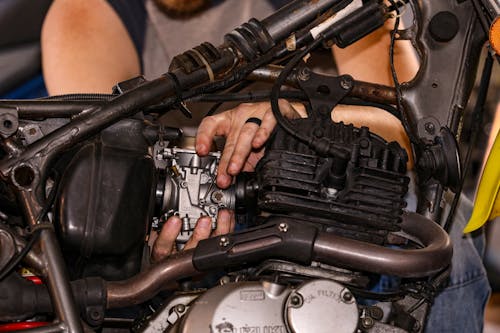 Free Close-Up Shot of a Person Fixing an Engine of a Motorcycle Stock Photo
