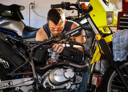 Mécanicien réparant le moteur d'une moto dans un garage