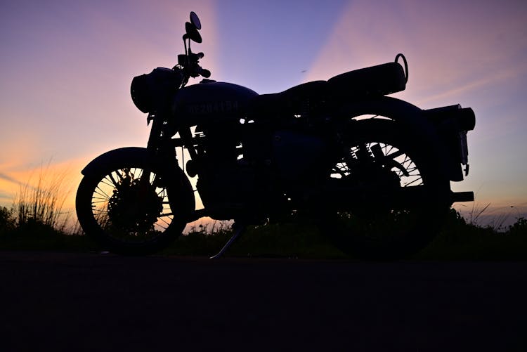 Motorcycle On Grass Field Under Purple Sky