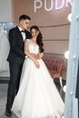 Man in Black Suit Jacket Hugging Woman in White Wedding Dress