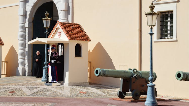 Cannons And Guards In Front Of A Yellow Building 