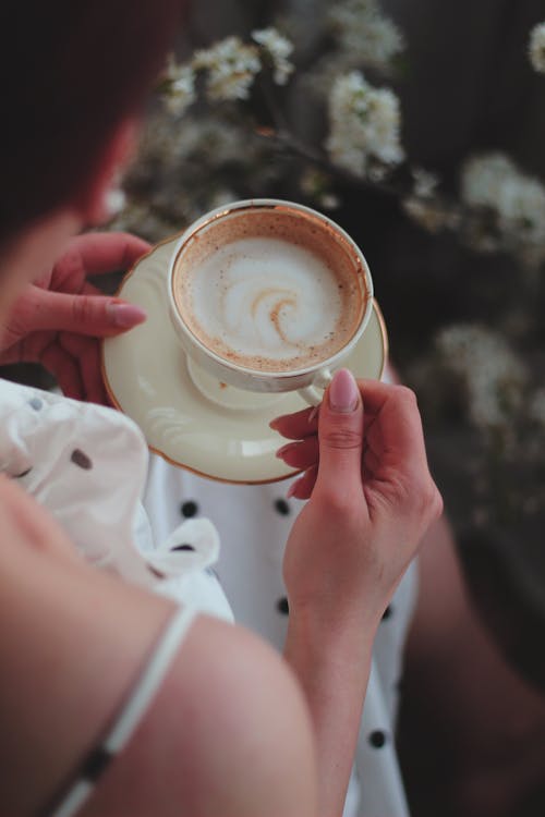 Free Close Up Photo of a Person Holding Cup of Coffee and a Saucer Stock Photo