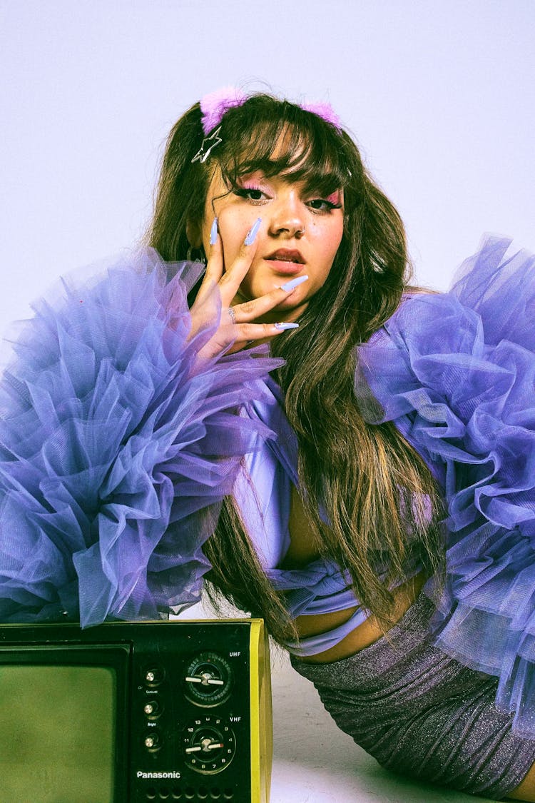 A Woman Wearing A Purple Top With Ruffles