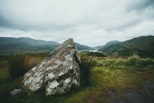 Free Dramatic mountain landscape with a large rock under cloudy skies. Perfect for nature and travel themes. Stock Photo