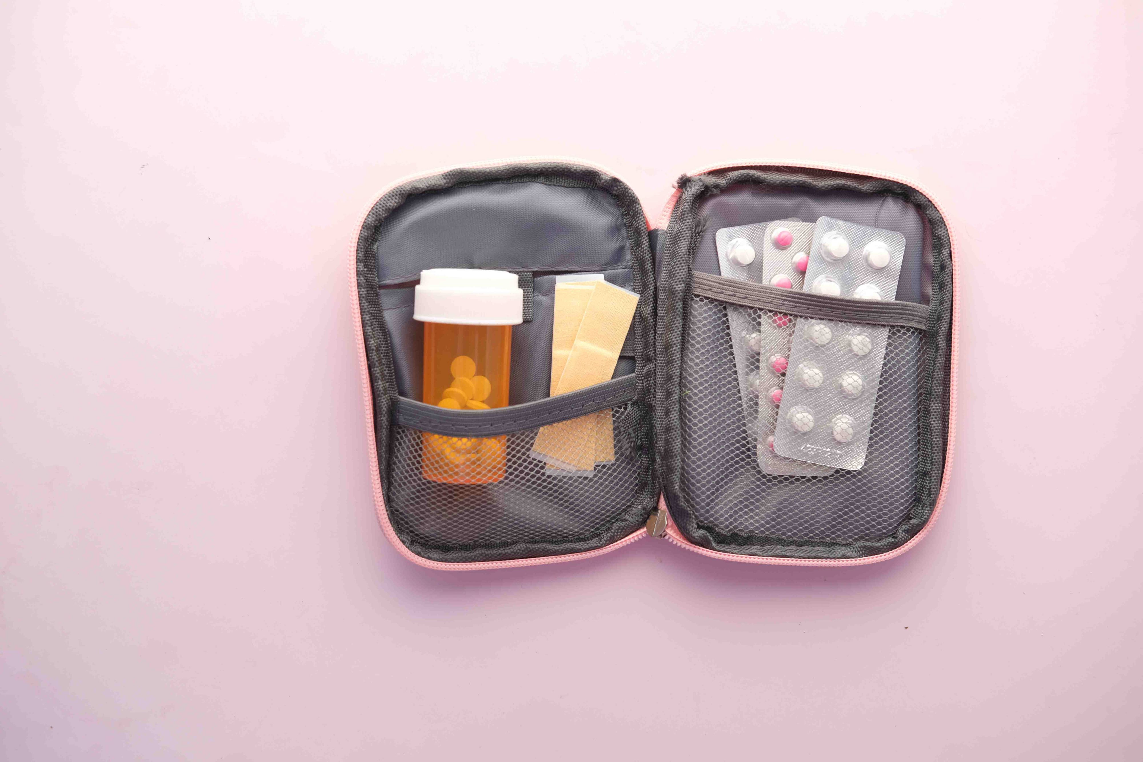 Trousse à pharmacie de voyage ouverte avec médicaments, pansements et plaquettes