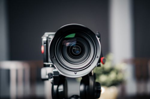 Free Close-up of a professional camera lens with a blurred background, focusing on the lens details. Stock Photo