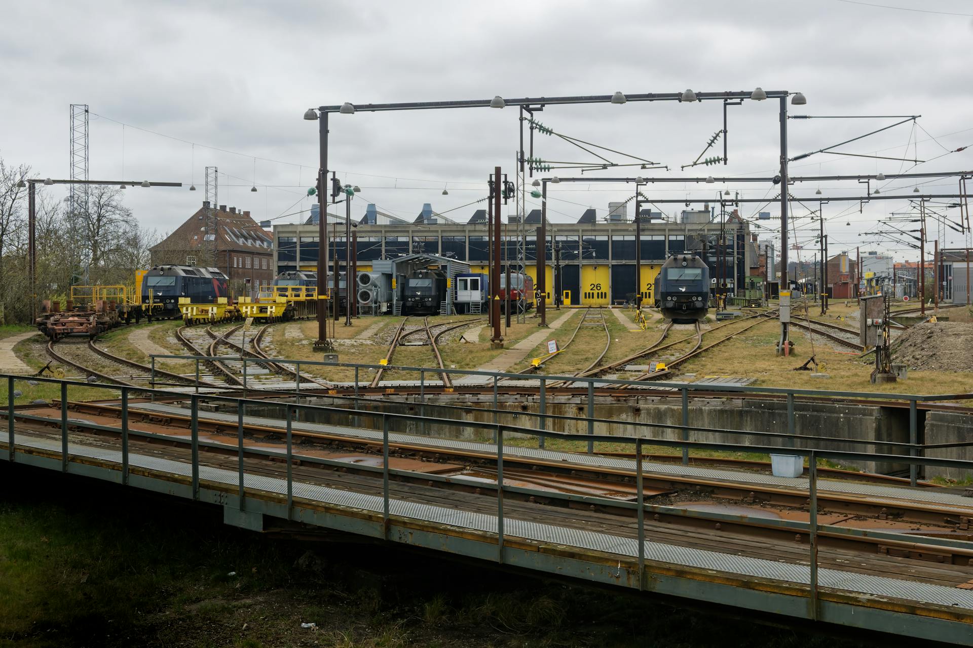 Rail yard in Copenhagen featuring train tracks, locomotives, and station infrastructure.