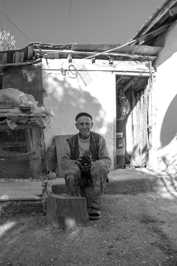 Grayscale Photo Of A Man Holding A Chicken