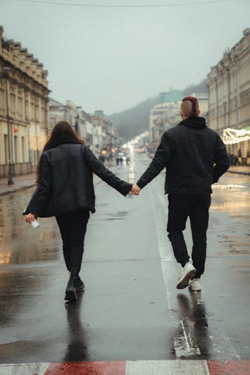 Free Back View of a Couple Walking on a Road while Holding Hands Stock Photo