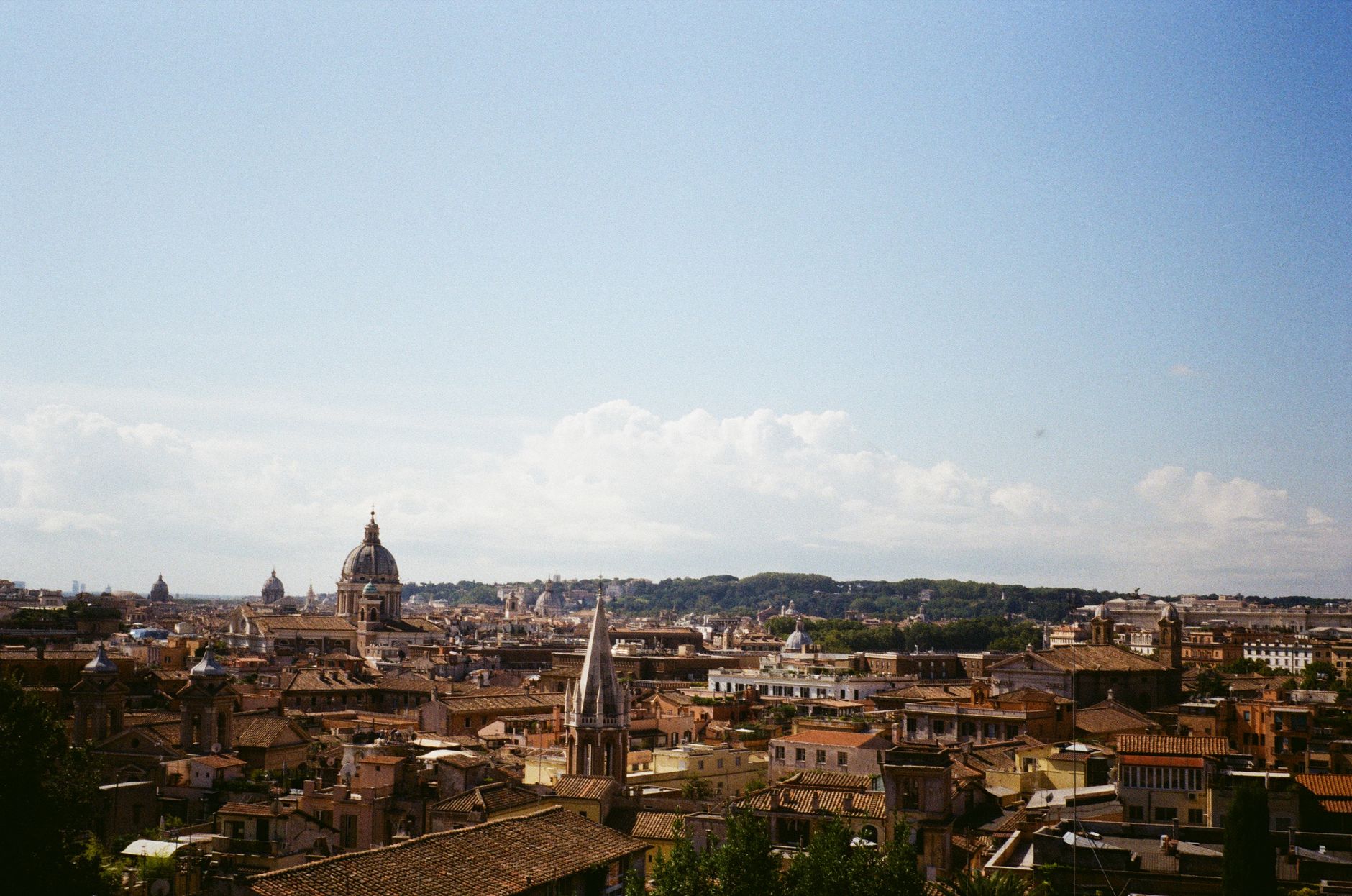 Aerial view of Rome showcasing historic architecture and vibrant cityscape under a blue sky.